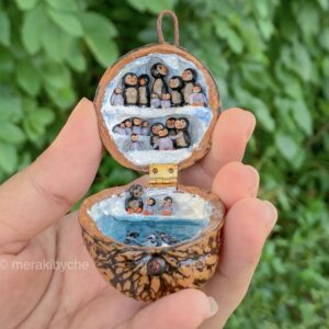 Miniature penguin scene inside a walnut